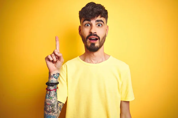 Ung Man Med Tatuering Bär Shirt Stående Över Isolerad Gul — Stockfoto