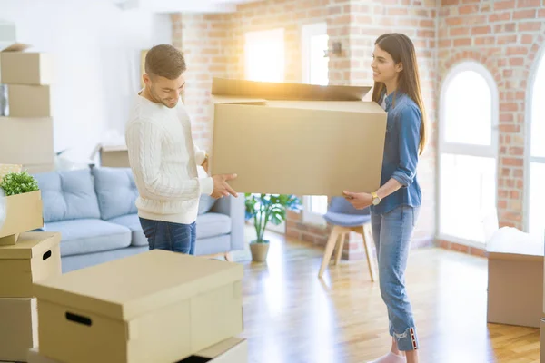 Hermosa pareja joven que se muda a un nuevo hogar, sosteniendo grandes cardboa — Foto de Stock