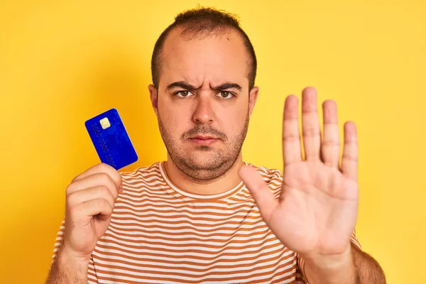 Jeune Homme Tenant Carte Bleue Crédit Debout Sur Fond Jaune — Photo