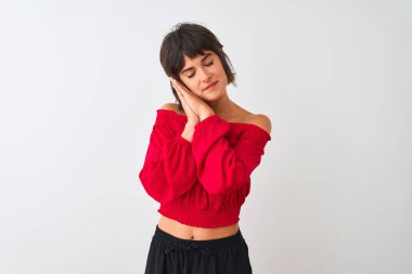 Kırmızı yazlık t-shirt giyen genç güzel kadın izole beyaz arka plan uyku yorgun rüya üzerinde duran ve kapalı gözlerle gülümseyerek birlikte elleri ile poz.
