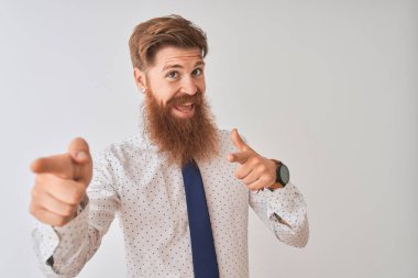 Genç kızıl saçlı İrlandalı işadamı izole beyaz arka plan üzerinde mutlu ve komik yüzü ile kameraya parmaklarını gösteren ayakta. İyi enerji ve titreşimler.