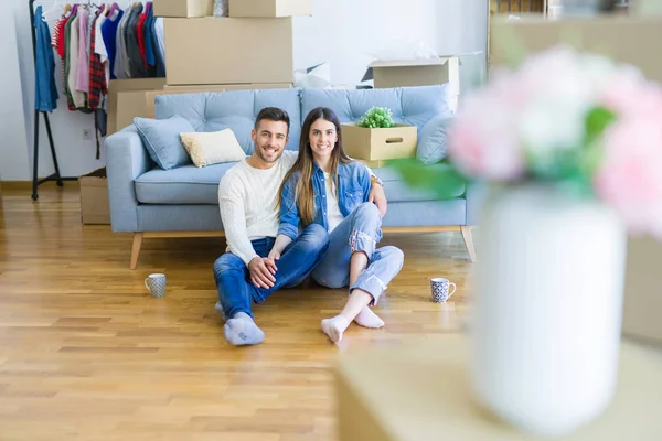 Junges schönes Paar sitzt auf dem Boden der neuen Wohnung, sm — Stockfoto