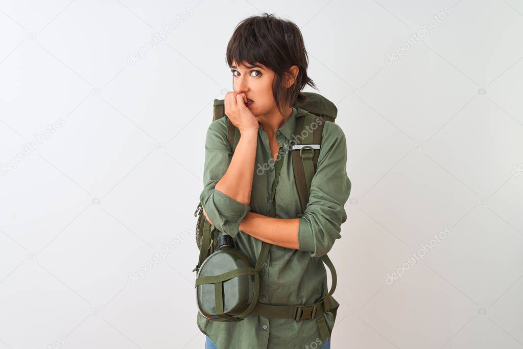 Beautiful hiker woman wearing backpack and water canteen over isolated white background looking stressed and nervous with hands on mouth biting nails. Anxiety problem.
