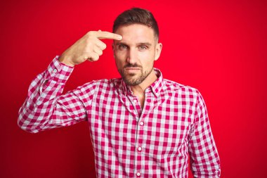 Kırmızı izole arka plan üzerinde genç yakışıklı adam alnında sivilce mutsuz işaret, siyah siyah çirkin enfeksiyon. Akne ve cilt sorunu