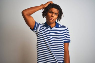 İzole beyaz arka plan üzerinde duran çizgili mavi polo giyen dreadlocks ile Afro adam karıştırmayın ve soru hakkında merak. Şüpheyle belirsiz, eliyle kafada düşünmek. Pensive kavramı.