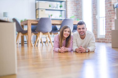 Aşk genç güzel çift yeni bir eve hareket, karton kutular etrafında yerde yatıyor, yeni daire için çok mutlu ve neşeli