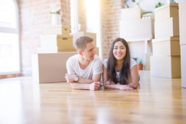 Genç güzel çift karton kutular etrafında yeni evde yatarken