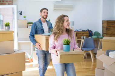 Yeni bir ev taşımak karton kutular tutarak birlikte çok mutlu genç güzel çift