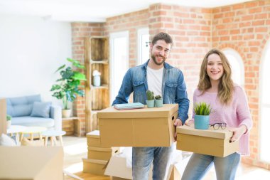 Yeni bir ev taşımak karton kutular tutarak birlikte çok mutlu genç güzel çift