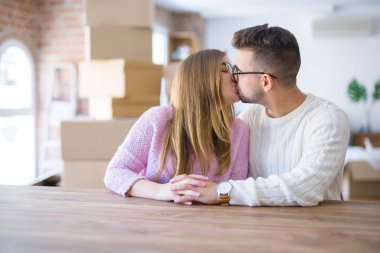 Genç güzel çift evde masada oturan, sarılma 