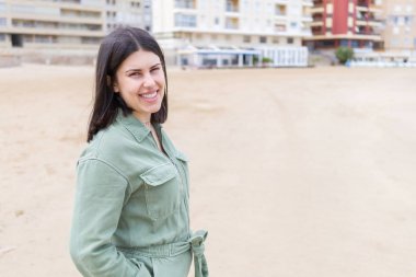 Genç güzel kadın plajda çok mutlu gülümseyen
