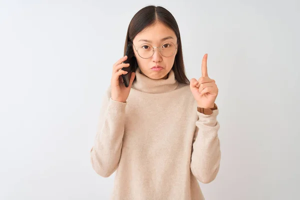 年轻的中国妇女说话在智能手机上孤立的白色背景指向上看悲伤和沮丧 用手指指示方向 不快乐和沮丧 — 图库照片