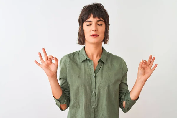年轻的漂亮女人穿着绿色休闲衬衫站在孤立的白色背景放松和微笑与眼睛闭着手指做冥想手势 瑜伽概念 — 图库照片