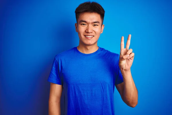 Joven Asiático Chino Hombre Usando Camiseta Pie Sobre Aislado Azul — Foto de Stock