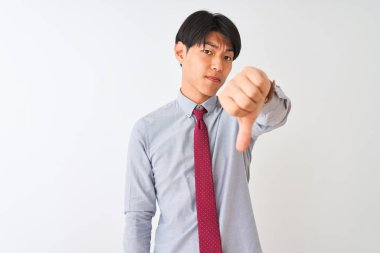 Izole beyaz arka plan üzerinde duran zarif kravat giyen Çinli işadamı mutsuz ve kızgın gösteren reddi gösteren ve aşağı jest başparmak ile negatif. Kötü ifade.