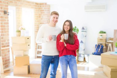 Yeni bir eve taşınmayı kutlayan bir fincan kahve içerek aşkiçinde gülümseyen genç çift