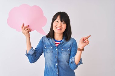Genç güzel Çinli kadın izole beyaz arka plan üzerinde bulut konuşma balonu tutan çok mutlu yan el ve parmak ile işaret
