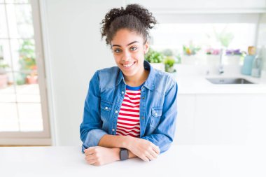 Yüzünde mutlu ve güzel bir gülümseme ile rahat denim ceket giyen afro saçlı güzel genç Afro-Amerikan kadın. Şanslı kişi.