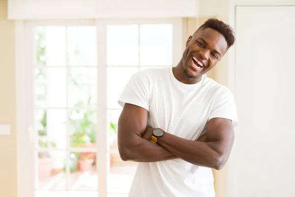 Beau jeune homme africain souriant gai avec les bras croisés — Photo