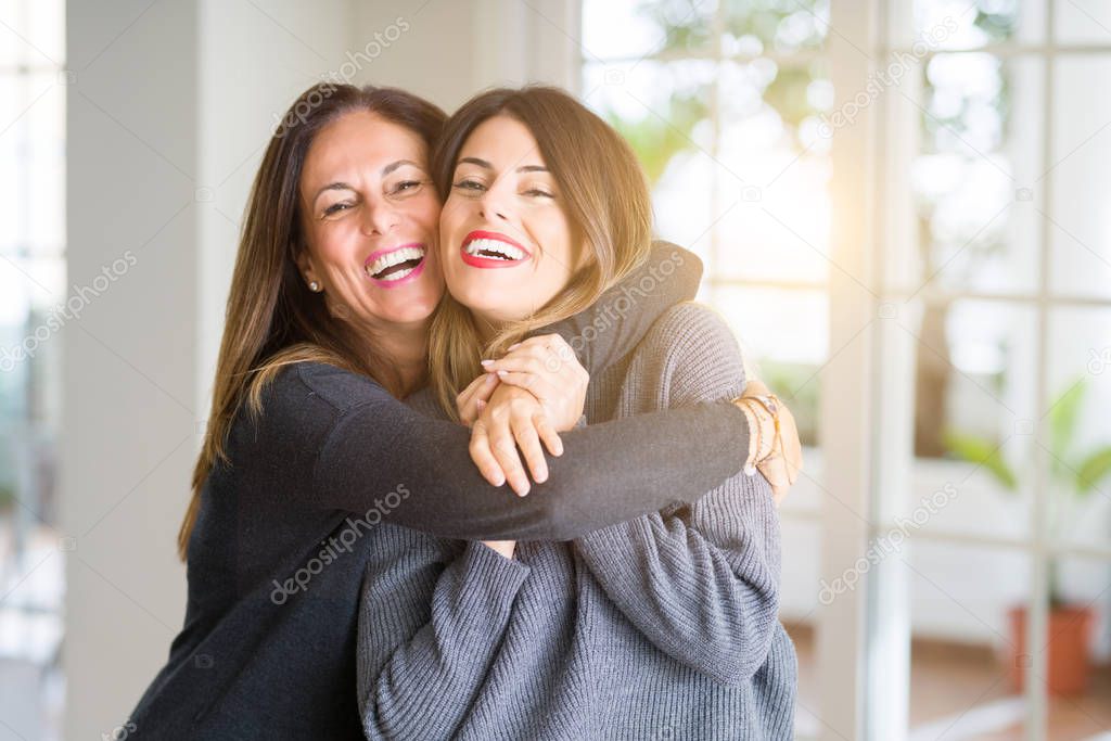 Beautiful family of mother and daughter together, hugging and kissing at home