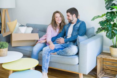 Genç çift içinde aşk sarılma oturma üzerinde the kanepe çok mutlu Moving için bir yeni ev