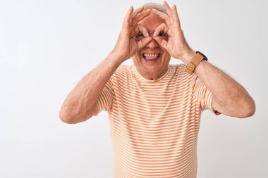 Üst düzey gri saçlı adam izole beyaz arka plan üzerinde duran çizgili t-shirt giyen dürbün dil dışarı yapışmasını gibi ok jest yapıyor, gözleri parmaklardan bakarak. Çılgın ifade.