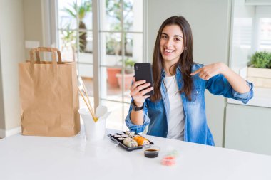 Akıllı telefonu kullanarak uygulamadan yemek siparişi veren güzel genç kadın, parmakla kendini işaret ediyor