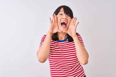 Genç güzel Çinli kadın izole beyaz arka plan üzerinde kırmızı çizgili t-shirt giyen Gülümseyen neşeli oynarken yüzleri gösteren elleri ile bir boo gözetleme. Şaşırttı ve çıktı