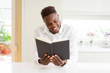 Genç Afrikalı adam bir kitap okuyor, univeristy smilin için okuyor