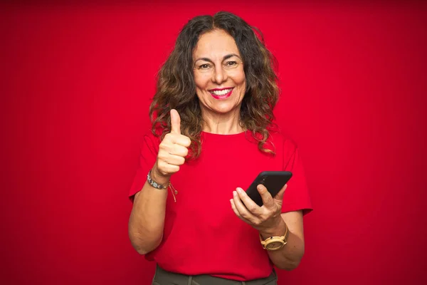 Seniorin Mittleren Alters Mit Smartphone Über Roten Isolierten Hintergrund Glücklich — Stockfoto