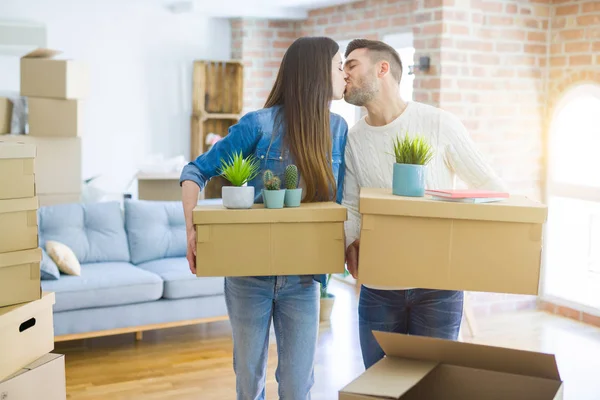 Jong paar verhuizen naar een nieuw huis, glimlachend gelukkig houden cardboa — Stockfoto