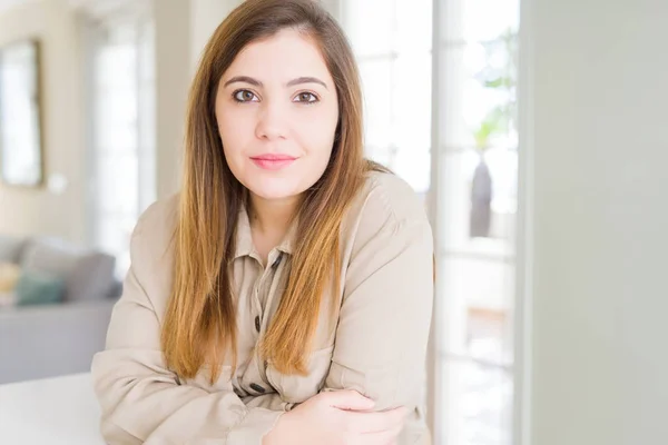 Beautiful young woman at home Relaxed with serious expression on face. Simple and natural with crossed arms