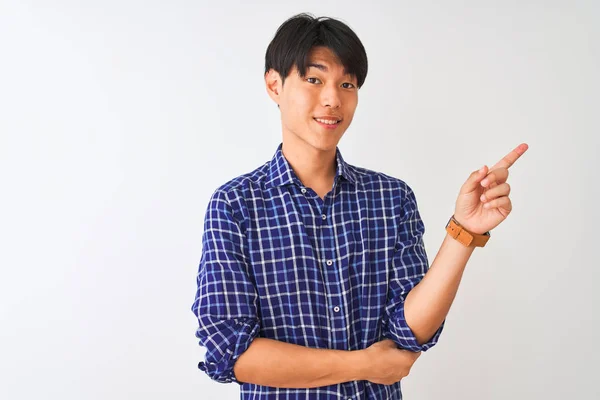 年轻的中国男子穿着休闲的蓝色衬衫站在孤立的白色背景上 脸上挂着灿烂的笑容 用手和手指指着一边看着镜头 — 图库照片