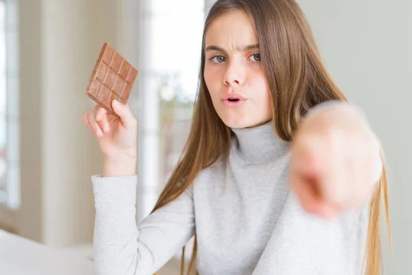 Schöne Junge Mädchen Kind Essen Schokoriegel Zeigt Mit Dem Finger — Stockfoto