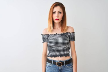 Izole beyaz arka plan üzerinde duran rahat t-shirt giyen güzel kızıl saçlı kadın yüzünde ciddi bir ifade ile rahat. Kameraya basit ve doğal bir bakış.