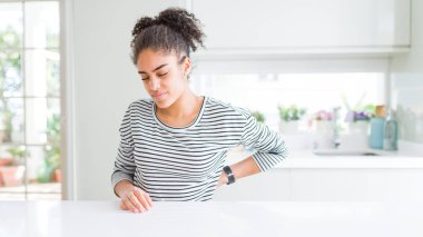 Afro saçlı güzel afro-amerikan kadın rahat çizgili kazak giyen sırt ağrısı Acı, el ile geri dokunmadan, kas ağrısı