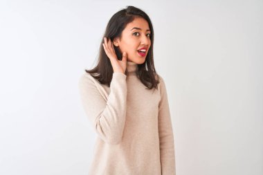 Balıkçı yaka kazak giyen güzel bir Çinli kadın izole edilmiş beyaz arka planda dikiliyor. Kulaktan kulağa gülümsüyor ve söylentiler ve dedikoduları dinliyor. Sağırlık kavramı.