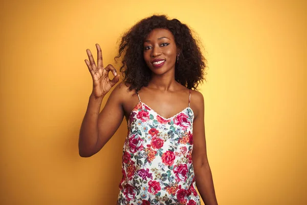孤立した黄色の背景に花の夏のTシャツを着たアフリカ系アメリカ人女性は 手と指でOkのサインをして肯定的な笑顔 成功した表現 — ストック写真