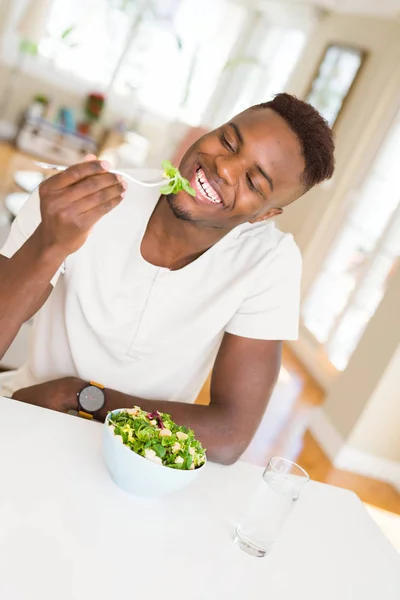 Pohledný africký mladík, který jedl zdravý zeleninový salát usin — Stock fotografie