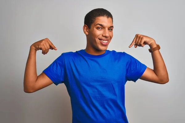 年轻英俊的阿拉伯男子 身穿蓝色T恤 站在孤独的白色背景上 面带微笑 用手指指着自己 自豪而快乐 — 图库照片
