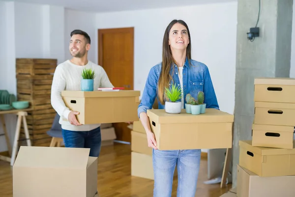 Giovane coppia si trasferisce in una nuova casa, sorridente felice holding cardboa — Foto Stock