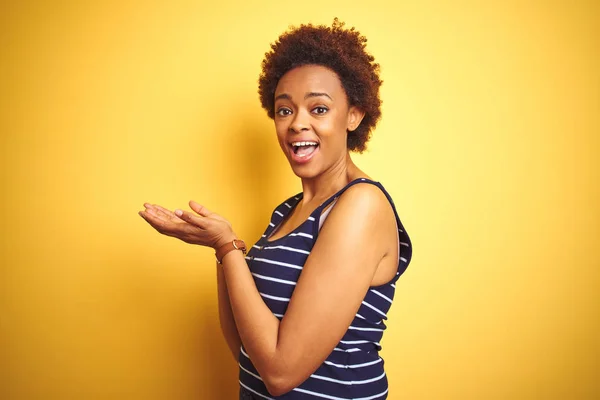 티셔츠를 아프리카계 미국인 여성이 고립된 노란색 손바닥을 가리키며 공간을 보여주는 — 스톡 사진