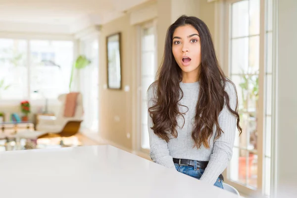 Young beautiful woman at home afraid and shocked with surprise expression, fear and excited face.