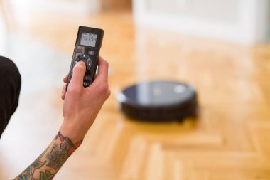 Adam elleri kontrol otomatik elektrikli süpürge kullanarak yakın 