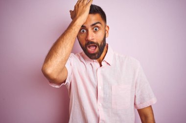 Izole pembe arka plan üzerinde duran rahat gömlek giyen genç hintli adam hata için kafasına el ile şaşırttı, hata hatırlıyorum. Unuttum, kötü bellek kavramı.