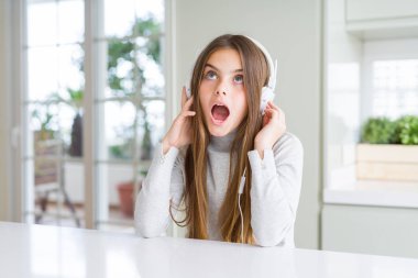 Kulaklık takan ve dans eden güzel genç kız sürpriz bir yüzle şokta korkmuş, korku ve korku yla heyecanlı ifade