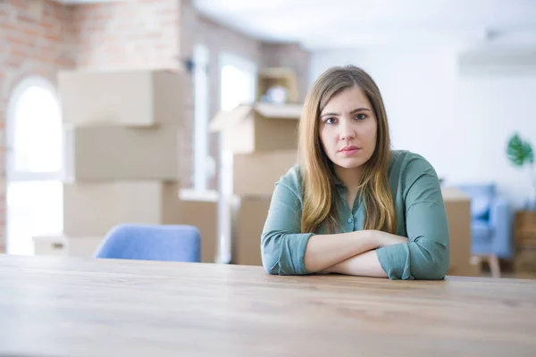Молодая Женщина Сидящая Столе Картонными Коробками Спиной Переезжая Новый Дом — стоковое фото
