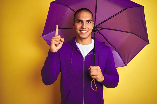 Young Handsome Man Wearing Purple Umbrella Yellow Isolated Background Surprised — Stock Photo, Image