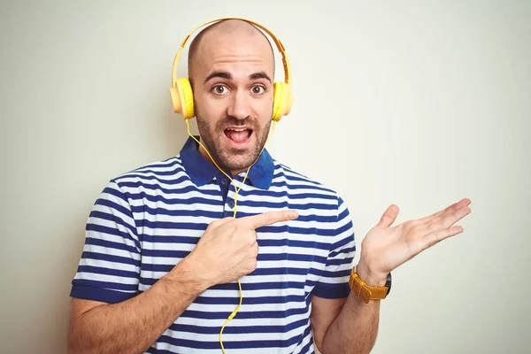 Mladý Muž Který Poslouchá Hudbu Žlutých Sluchátkách Izolovaném Pozadí Žasl — Stock fotografie