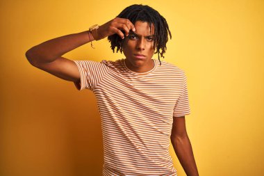 Çizgili t-shirt giyen dreadlocks ile Afro adam alnında sivilce için mutsuz işaret izole sarı arka plan üzerinde duran, siyah kafa çirkin enfeksiyon. Akne ve cilt sorunu